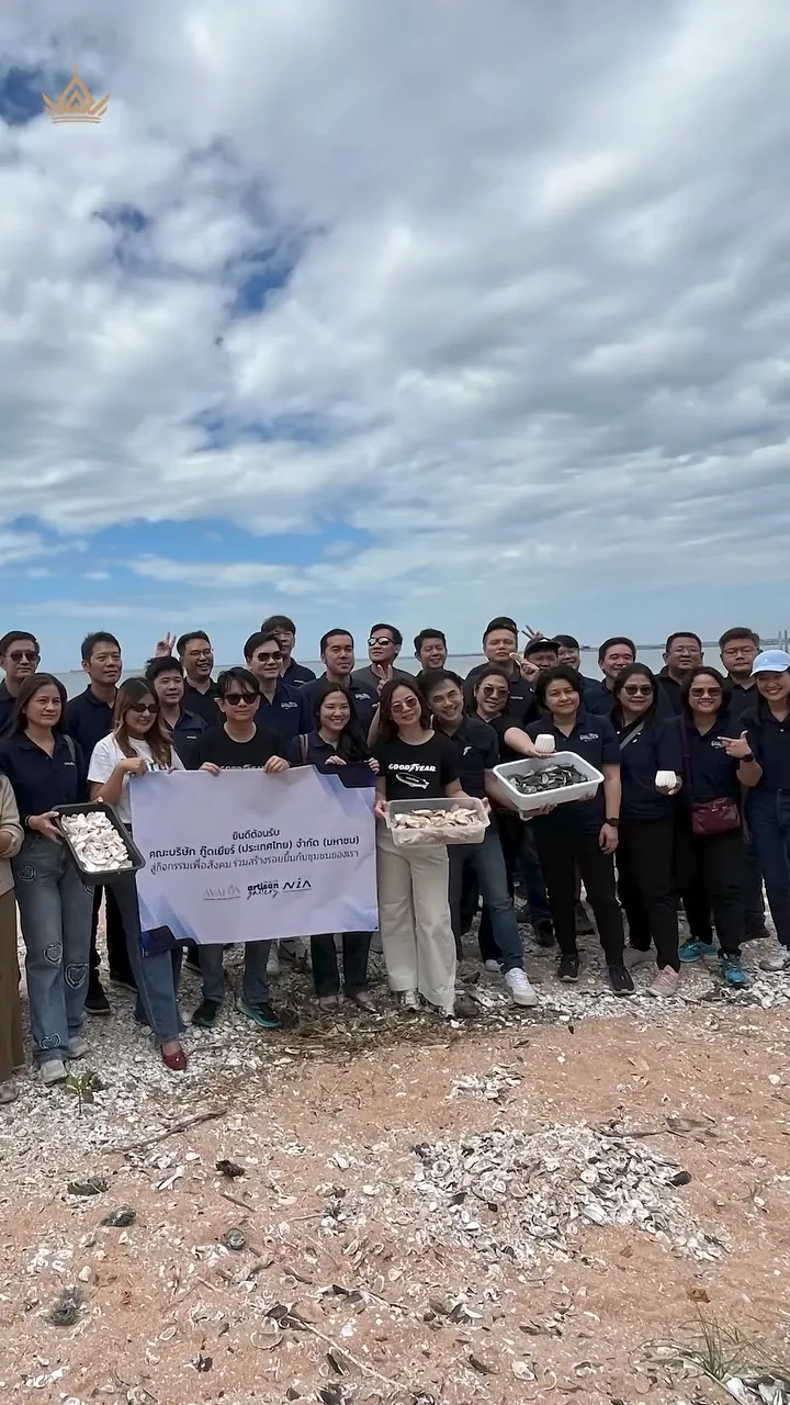The Goodyear team by the shore with the project banner