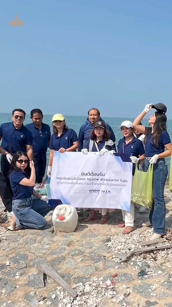 The Novotel team by the sea with the project banner