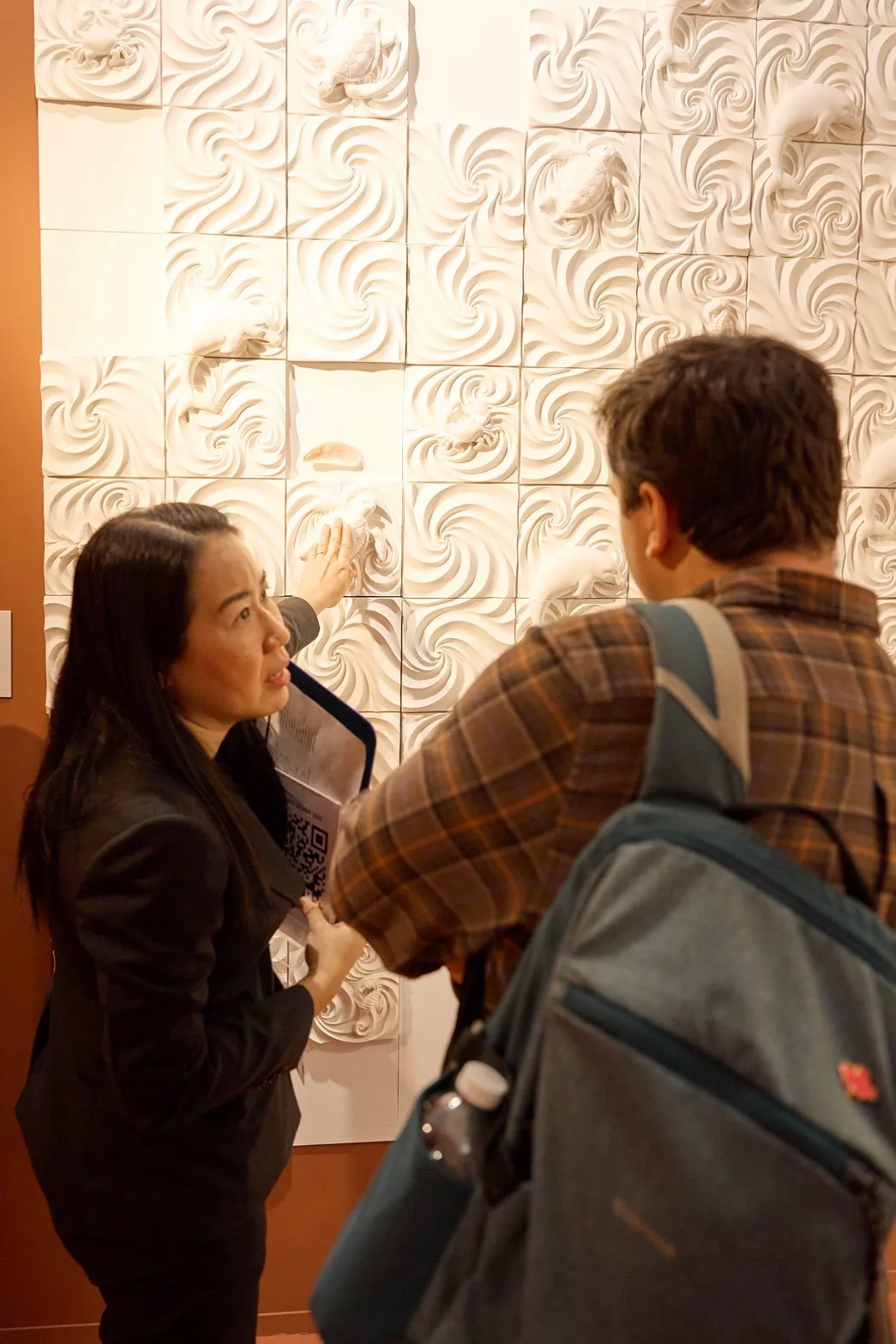A visitor touches the MyraShell tiles of Sea of Love