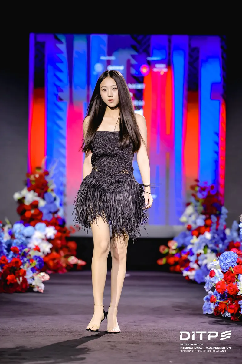 A model in a black feathered dress