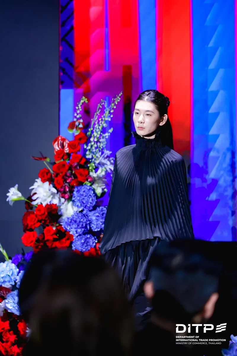 A model in a pleated black outfit