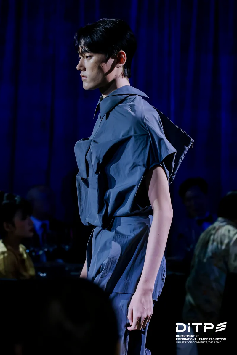 A model in a dark short-sleeved jumpsuit