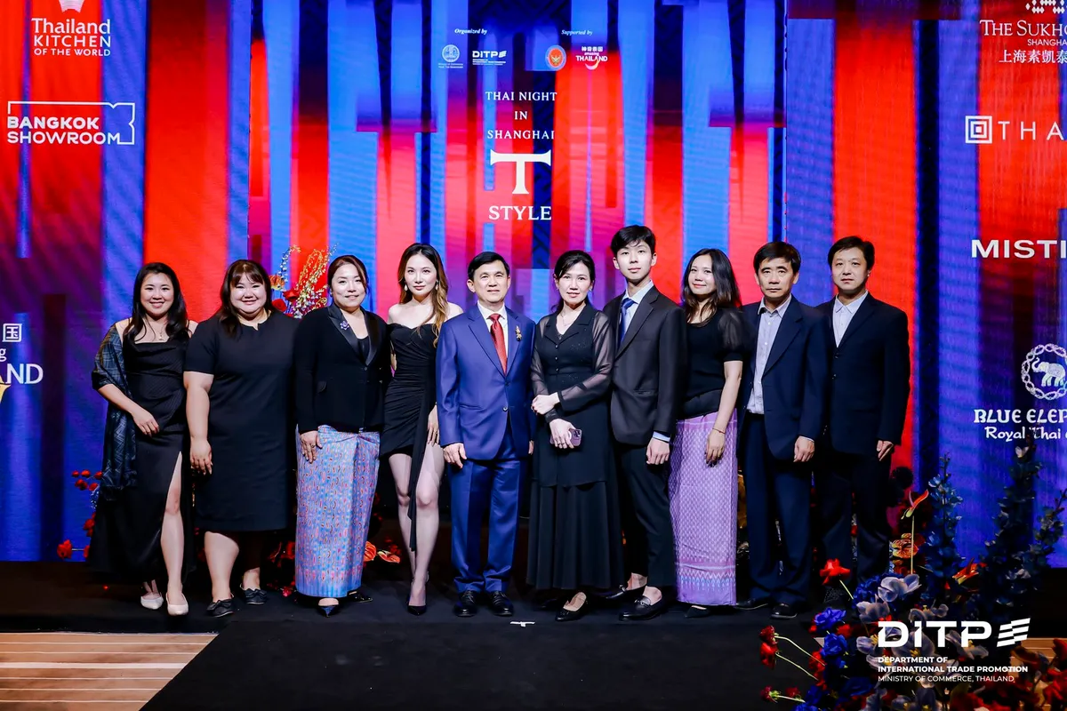 A large group on stage in front of the Thai Night in Shanghai backdrop