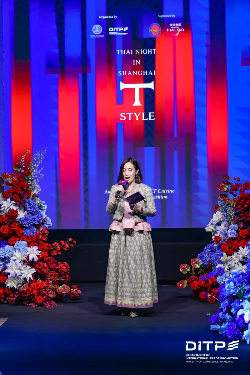 A speaker in a Thai-style outfit on stage