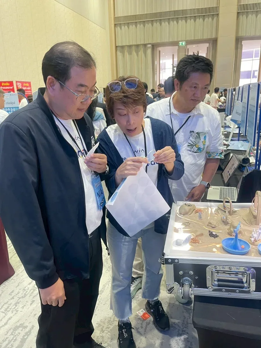 Visitors hold Sea Soul figures at the display case